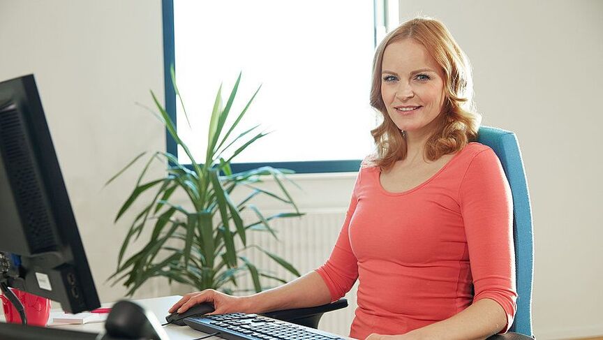 A woman in an ergonomic workplace is relieved of back pain